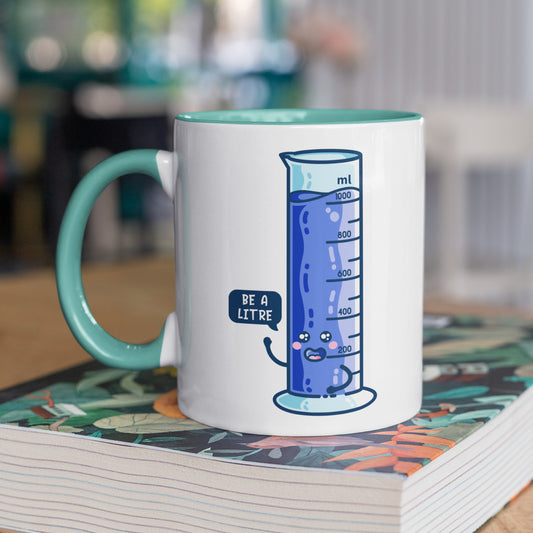 White and spearmint coloured ceramic mug with handle to the left and the kawaii cute be a litre graduated cylinder design printed on it