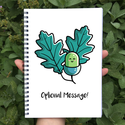 Closed notebook with white cover showing personalisation and acorn design