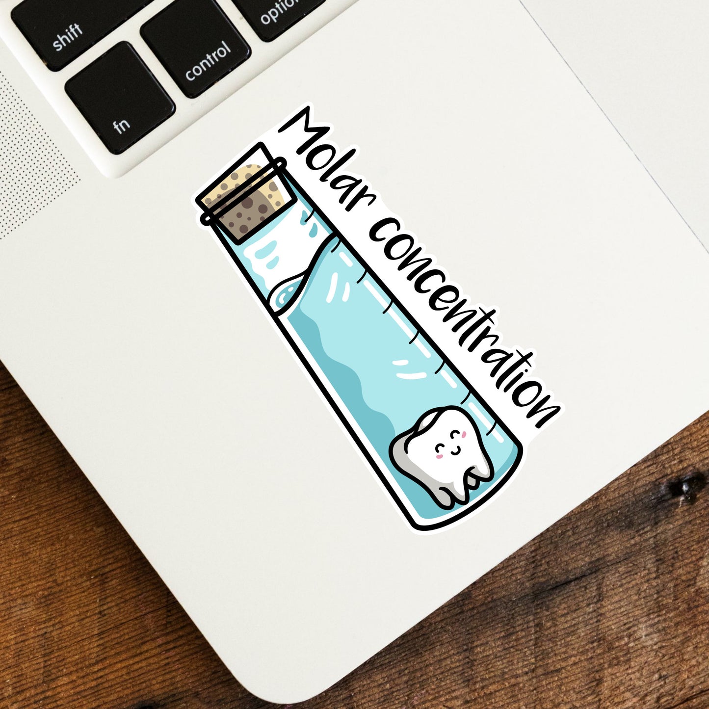 A shaped vinyl sticker of a molar tooth in a vial of liquid with a cork in the top and the words molar concentration down the side stuck onto the bottom left hand corner of a laptop computer keyboard