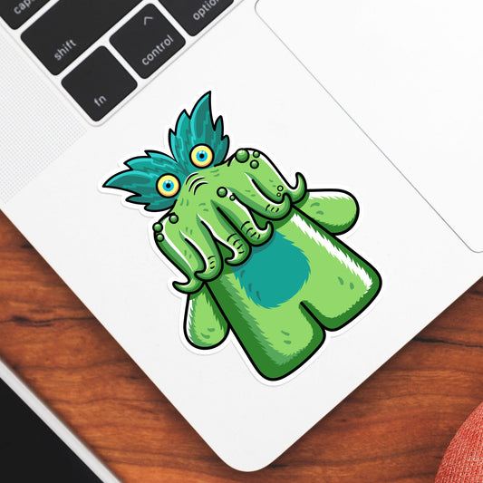 A shaped green vinyl sticker of the tickle-me-wiggly toy shown stuck onto the bottom left hand corner of a laptop computer keyboard