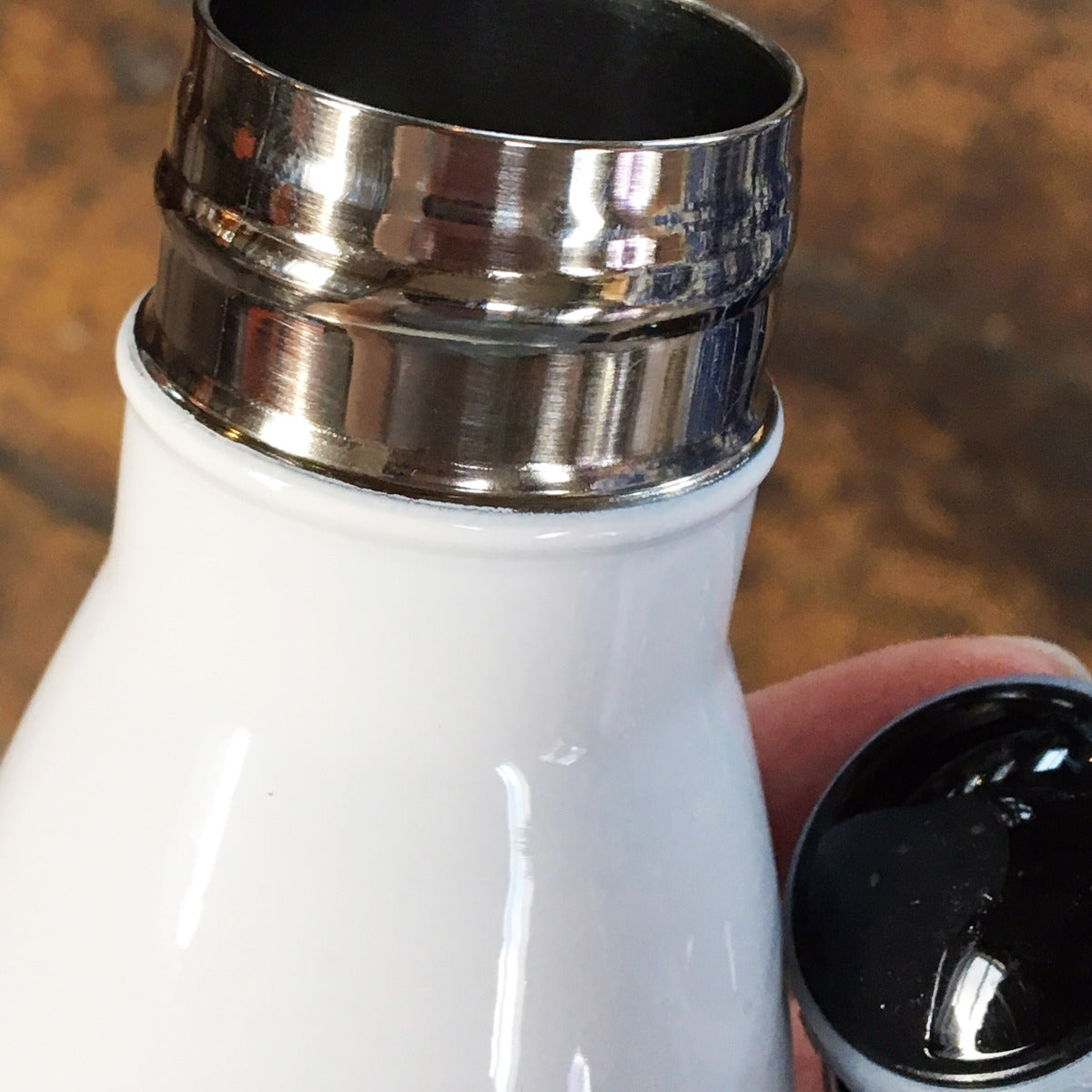 Photo showing the silver neck openning of the bottle with the lid removed.