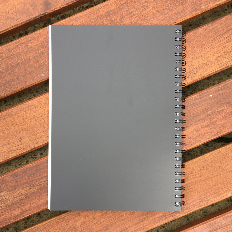 The notebook shown lying face down so that you can see that the back cover is completely plain black in colour.