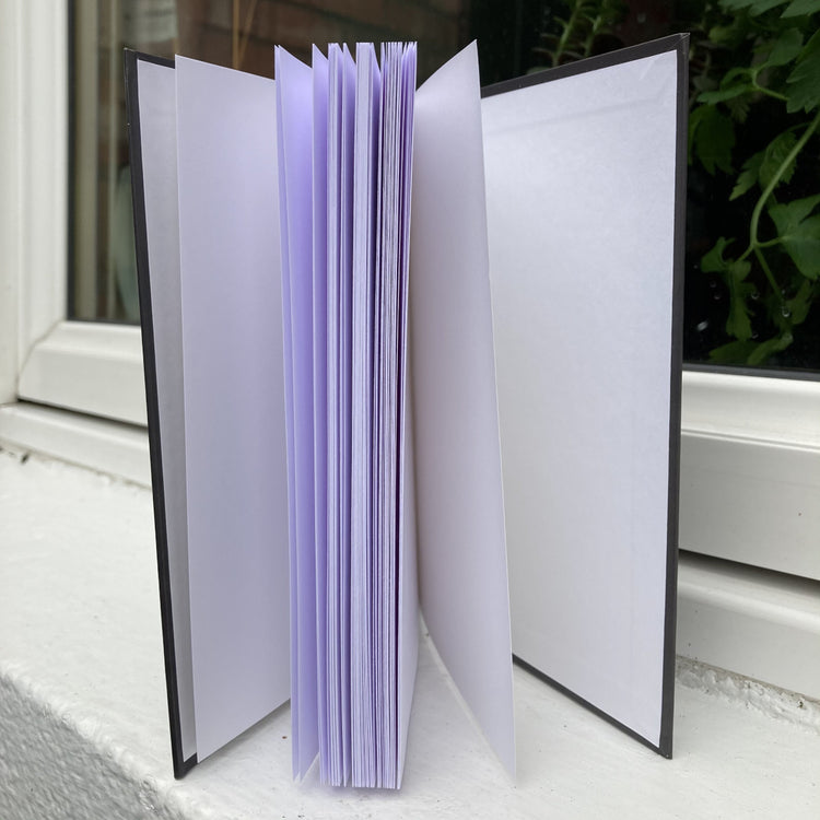 Hardback journal standing open showing plain white pages within