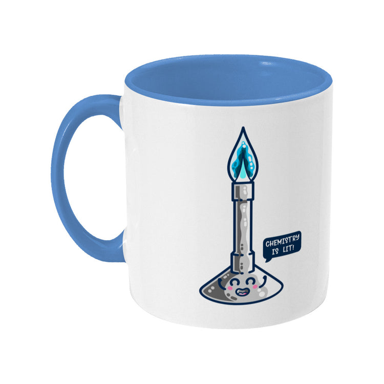 A blue and white two toned ceramic mug with the handle to the left and a design of a cute Bunsen burner with blue flame and speech bubble saying chemistry is lit!