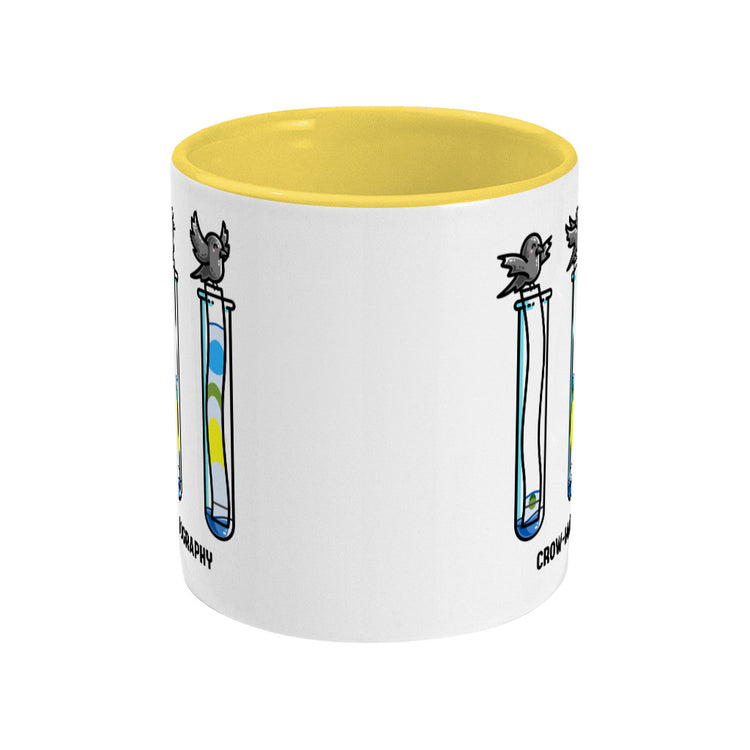 A two toned white and yellow ceramic mug seen side on with the handle hidden behind and a portion of the design visible at each edge of the mug.