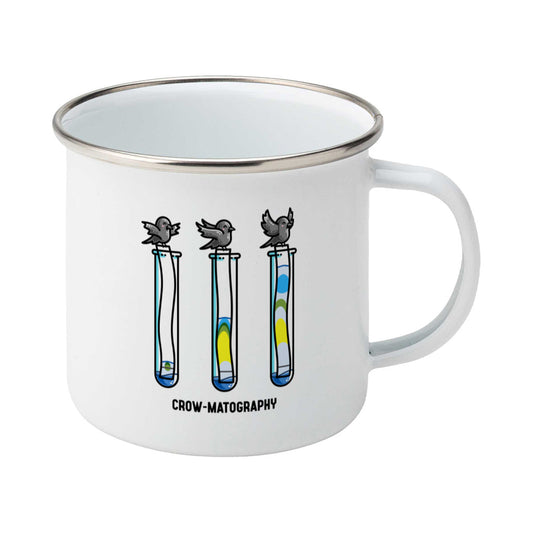 A silver rimmed white enamel mug with the handle to the right showing a design of 3 crows holding strips of paper into 3 test tubes showing colour separation.