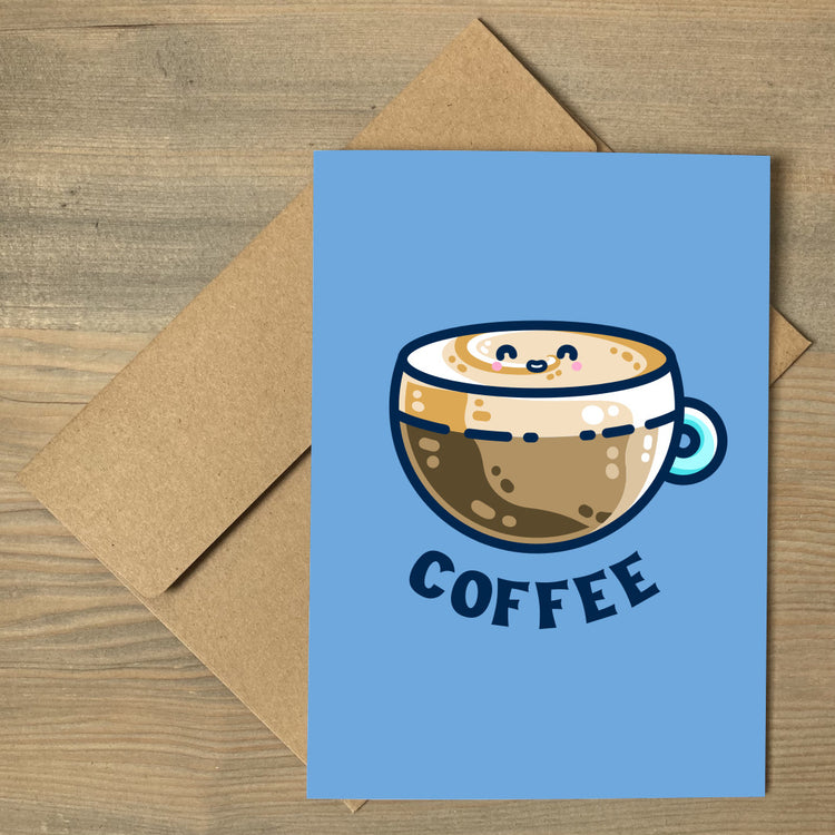 A blue greeting card lying flat on top of a brown envelope. In the center of the card is a design of a kawaii cute glass cup of coffee with a thick creamy layer at the top and a smiling face in the cream on the top. The word coffee is in capital letters beneath.