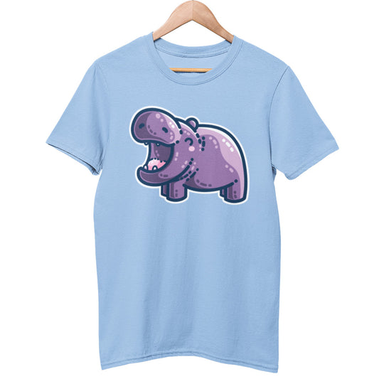 A pale blue unisex crewneck t-shirt on a wooden hanger. On the chest is a kawaii cute purple hippo with a thick dark blue outline. The hippo is seen side on facing to the left and looks happy with its mouth open wide.