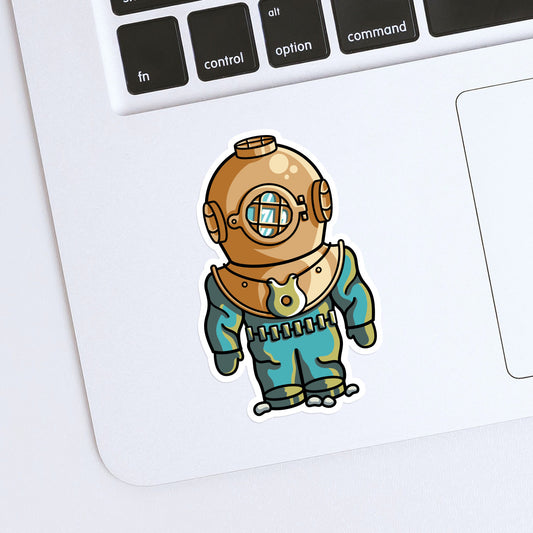 A shaped vinyl sticker of an old fashioned style diving suit with bronze coloured helmet shown stuck onto the bottom left hand corner of a laptop computer keyboard