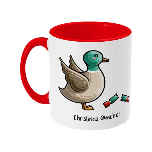 A two toned white and red ceramic mug with the handle to the left showing a design of a mallard duck with a red and green Christmas cracker and the words Christmas Quacker written in black beneath