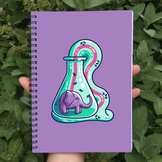 Closed notebook showing the purple front cover and elephant toothpaste design