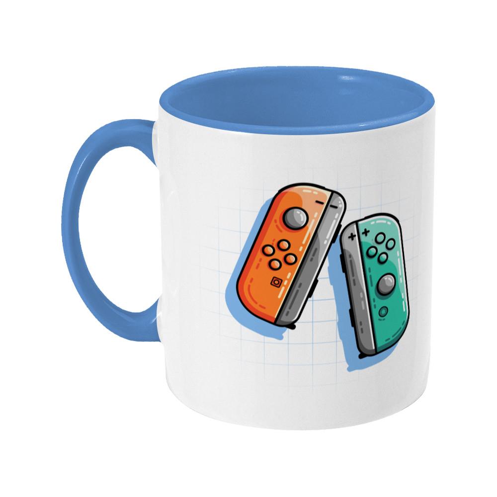 An orange and a turquoise game controller design on a two toned navy and white ceramic mug, showing LHS