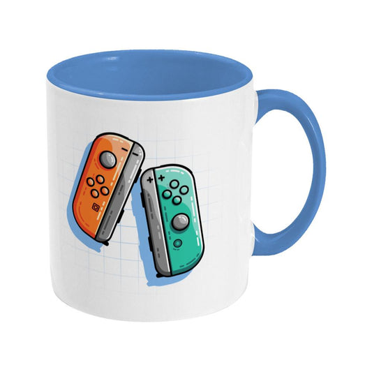 An orange and a turquoise game controller design on a two toned navy and white ceramic mug, showing RHS