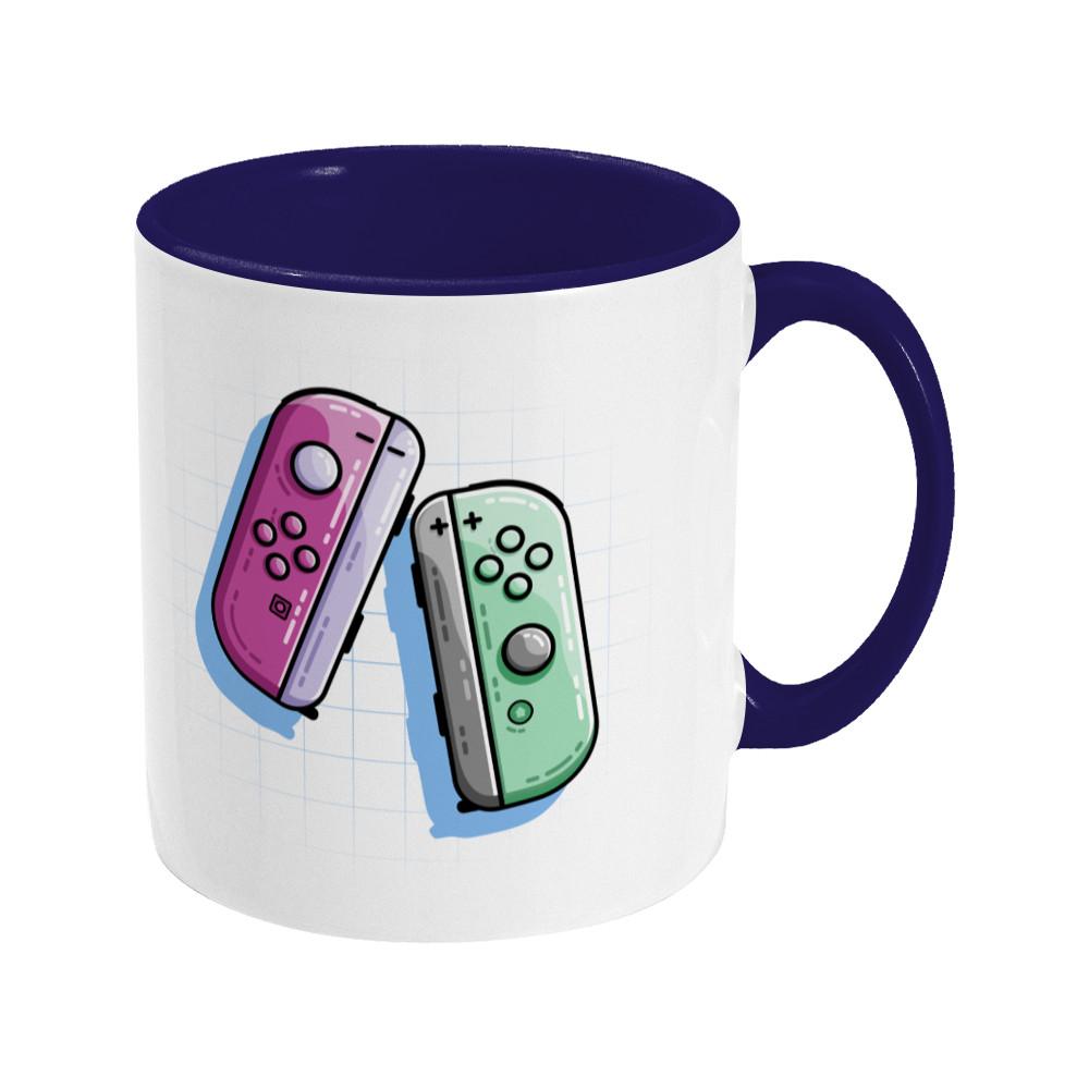 A pink and a green game controller design on a two toned navy and white ceramic mug, showing RHS