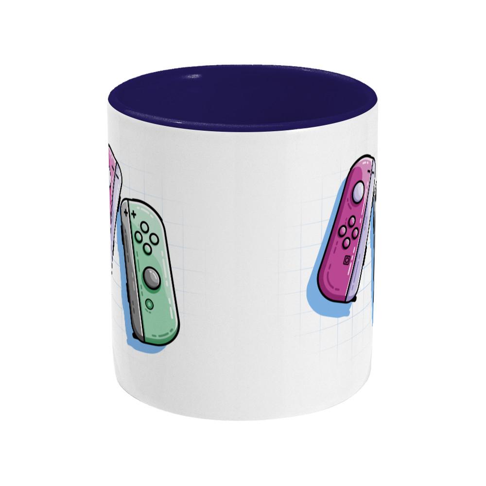 A pink and a green game controller design on a two toned navy and white ceramic mug, side view