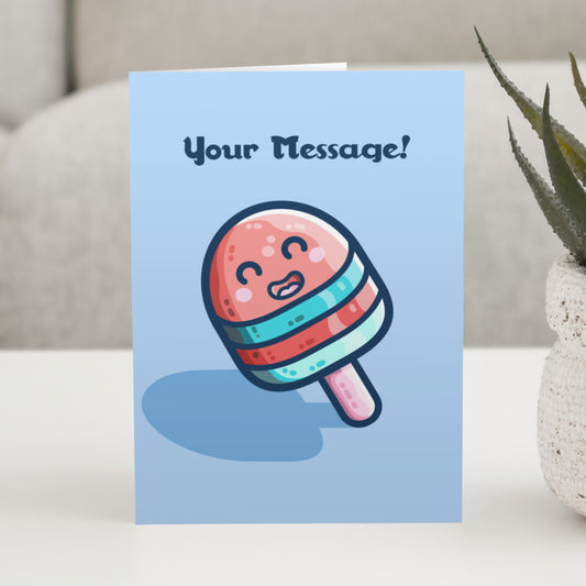 A blue greeting card standing on a white table, with a design of a blue and red striped kawaii cute ice lolly on a stick and with a personalised message above