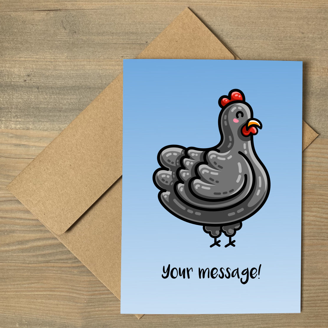A blue gradient greeting card lying a flat on a brown envelope, with the design of a kawaii cute black chicken and the personalised text 'your message!' beneath