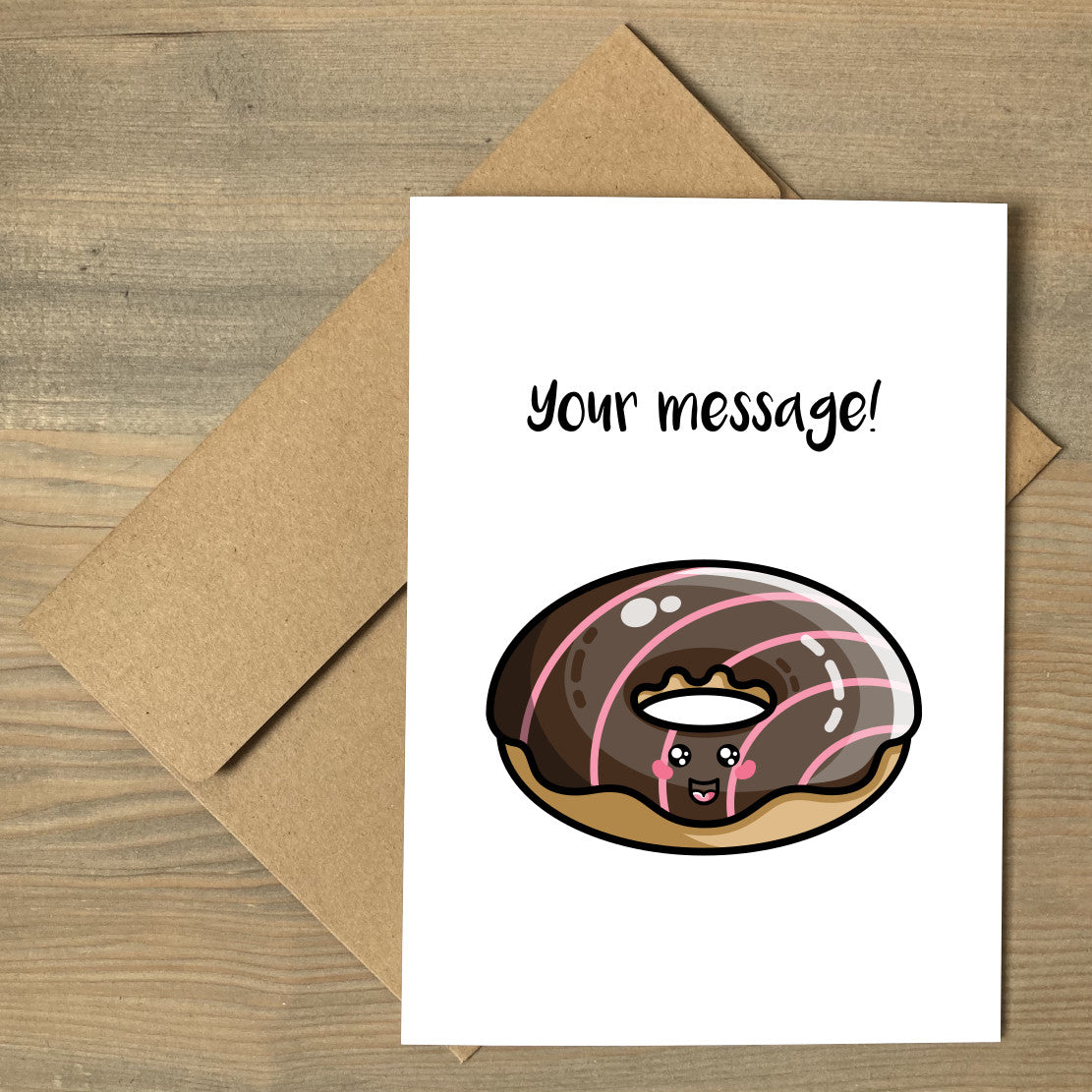 A white greeting card lying flat on a brown envelope, with a design of a kawaii cute chocolate iced doughnut with your own personalised message above.