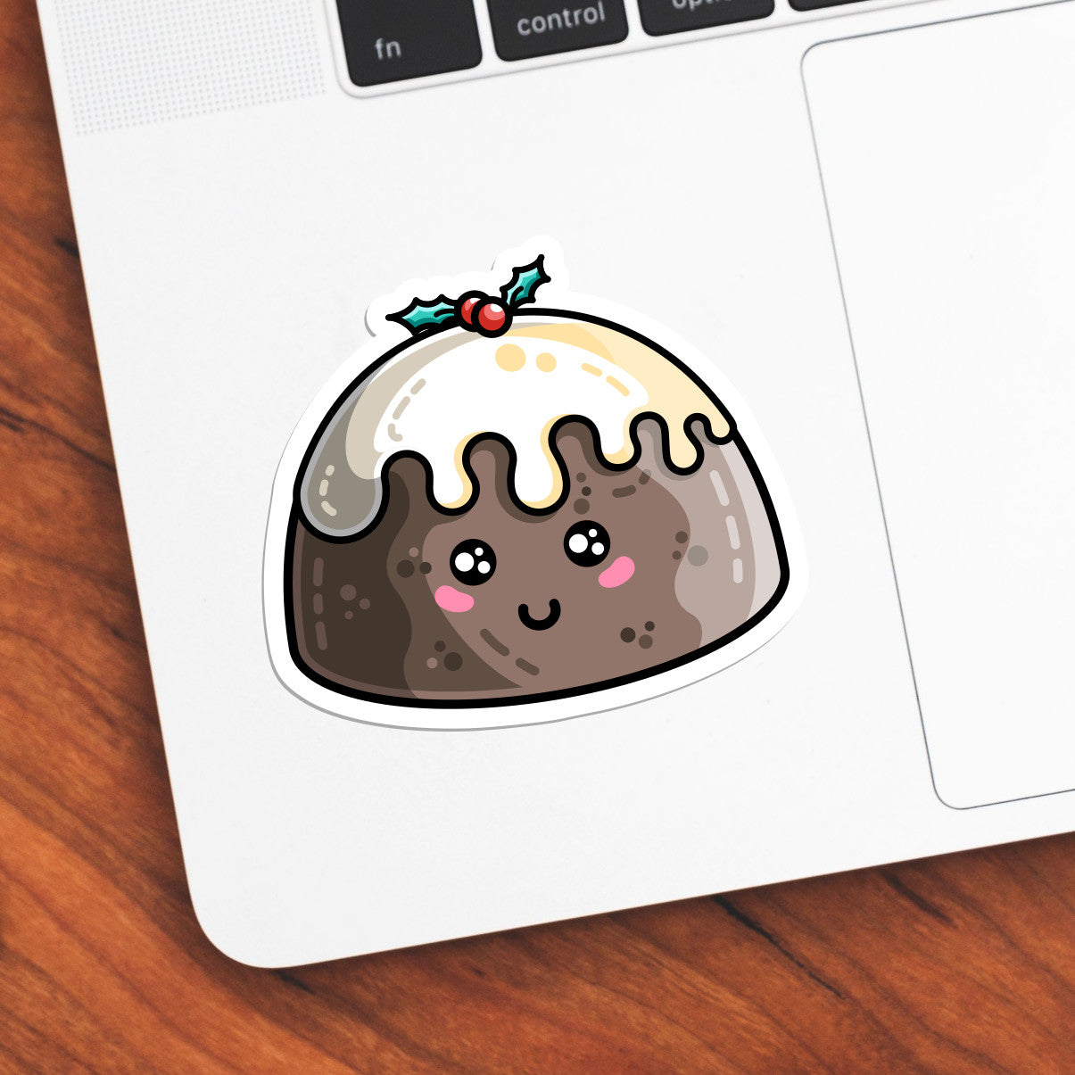 The corner of a laptop keyboard with a cute Christmas pudding die cut vinyl sticker stuck onto it