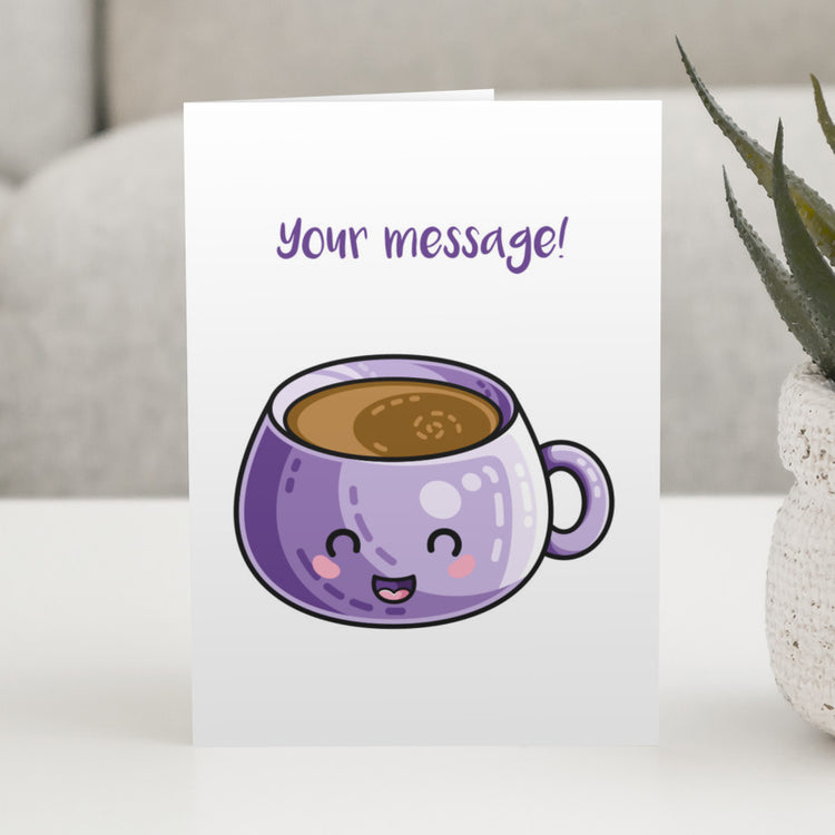 A white greeting card standing on a white table, with a design of a bulbous kawaii cute purple mug of coffee and a personalised message above