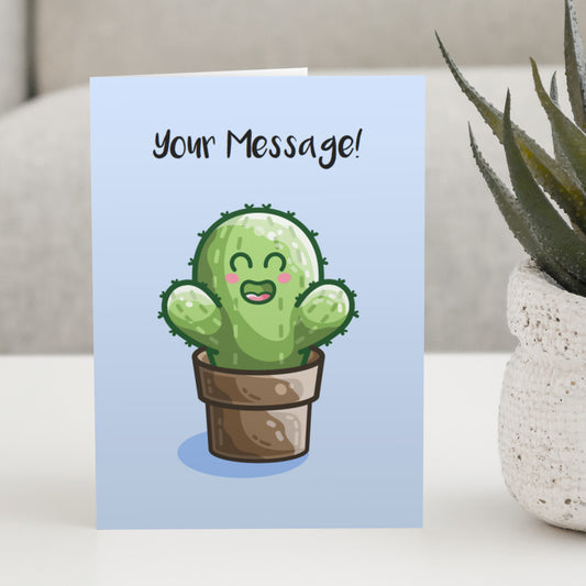 A blue greeting card standing on a white table with a design of a kawaii cute green cactus in a brown plant pot with a personalised message above.