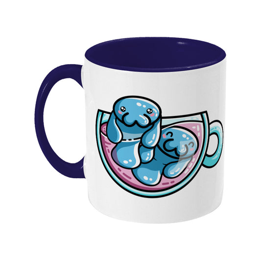 Two cute blue manatees swimming in a glass teacup design on a two toned blue and white ceramic mug, showing LHS