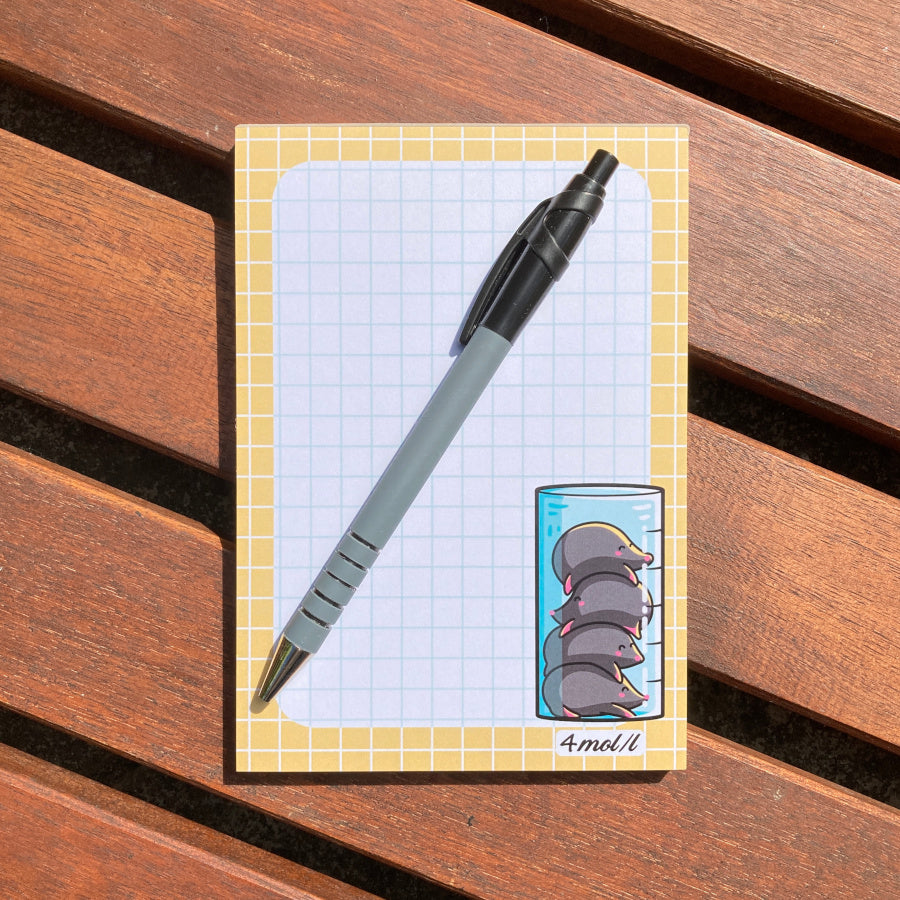 The notepad lying flat with a pen lying diagonally on top.