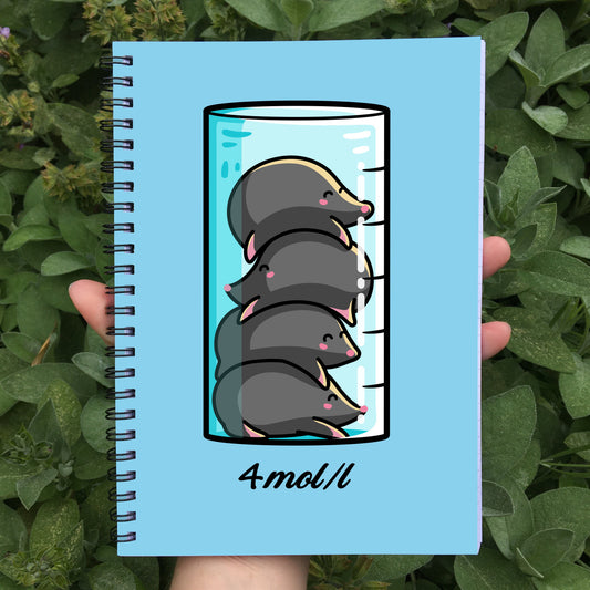 Closed notebook showing blue front cover with a design of 4 cute moles in a beaker