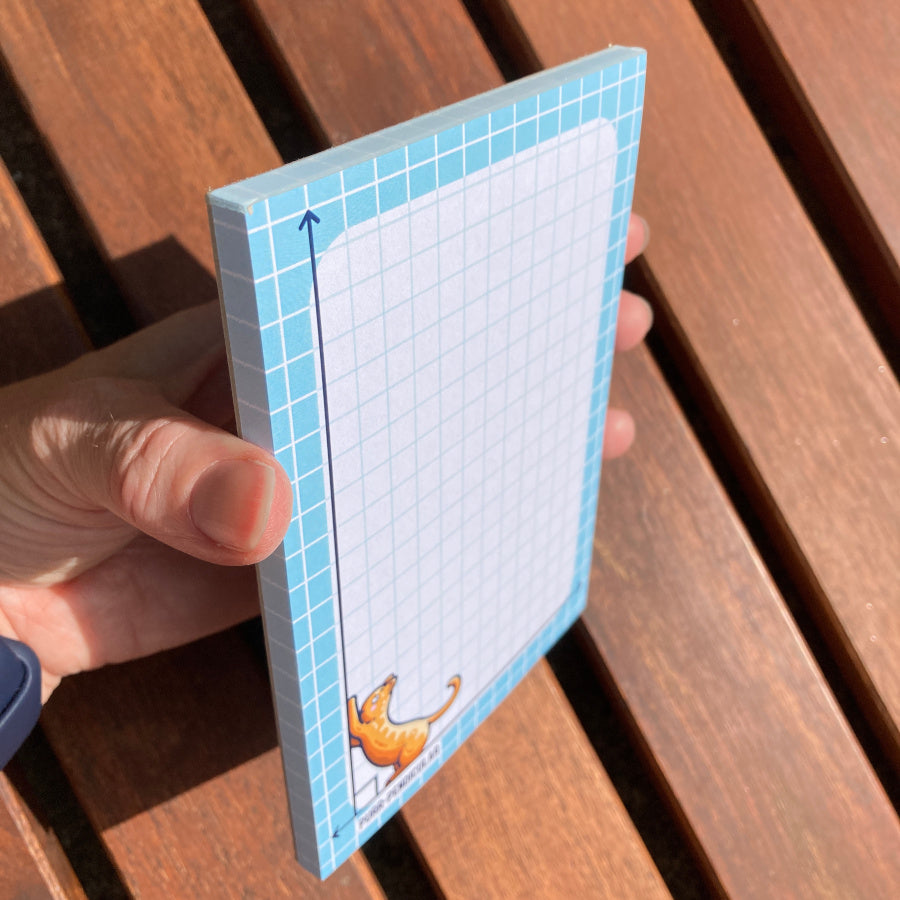 Holding the notepad at an angle, to see the thickness of the notepad.