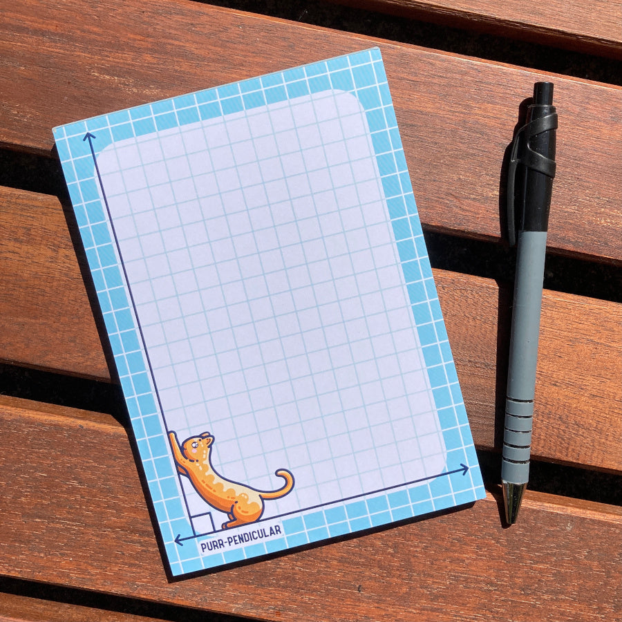 The notepad lying flat with a pen lying next to it.