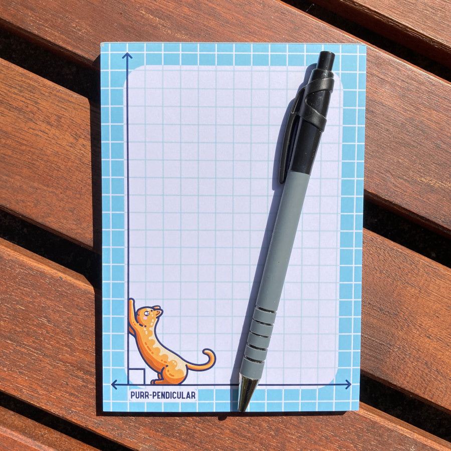 The notepad lying flat with a pen lying diagonally on top.