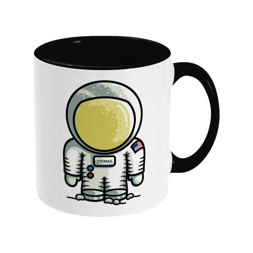 A two toned black and white ceramic mug, handle to the right, with a personalised design of a cute astronaut.
