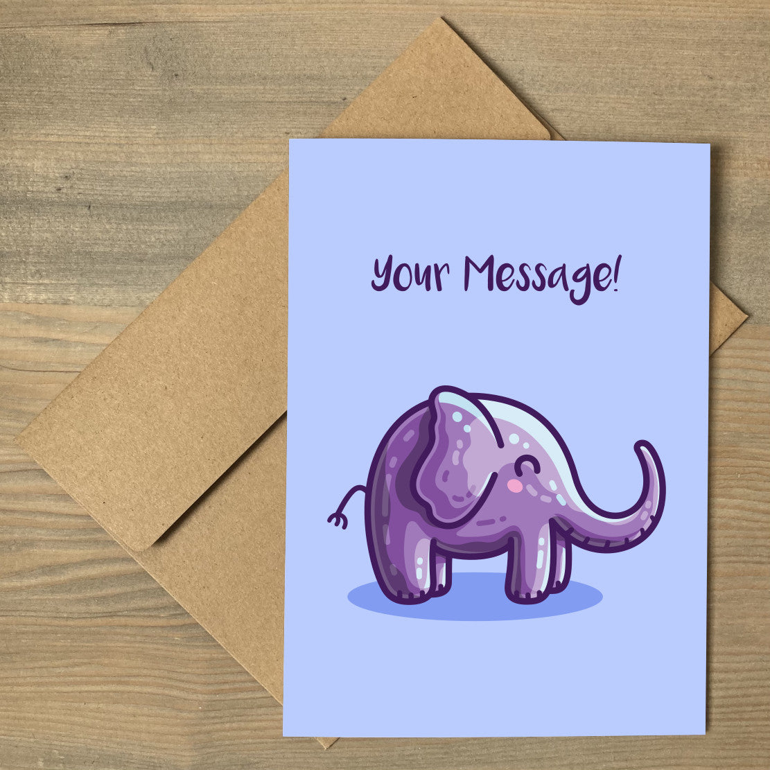 A blue greeting card lying flat on a brown envelope, with a design of an adorable cute purple elephant facing to the right and with personalised wording above