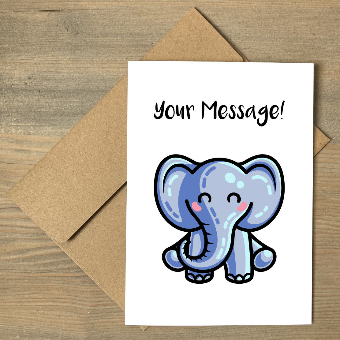 A white greeting card lying flat on a brown envelope featuring a kawaii cute blue elephant design with the personalised words Your Message written above