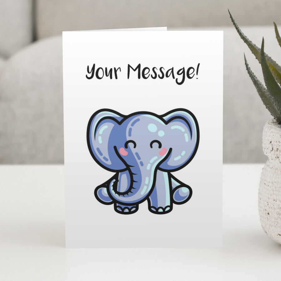 A white greeting card standing on a white table featuring a kawaii cute blue elephant design with the personalised words Your Message written above