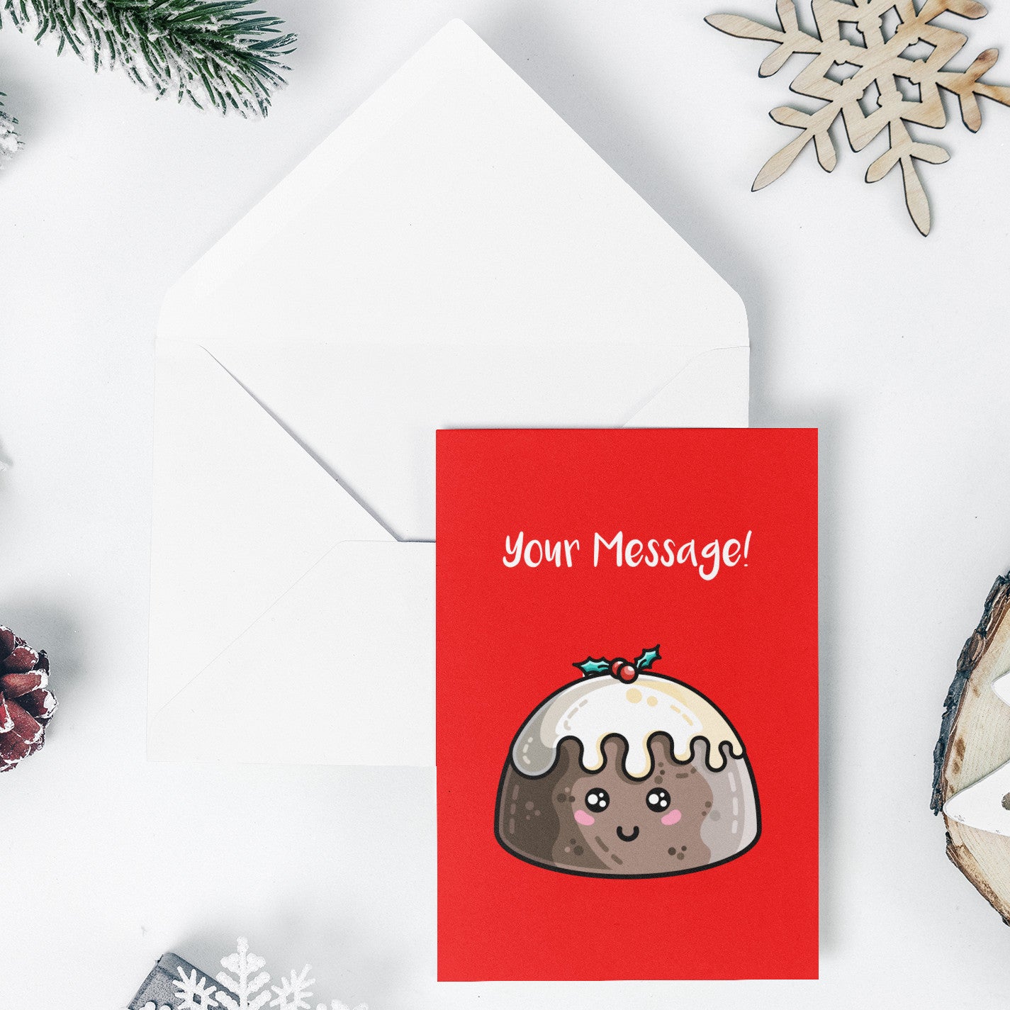 An open white envelope beneath a red greeting card with a design of a kawaii cute smiling Christmas pudding with cream on top and a sprig of holly and your message in white above