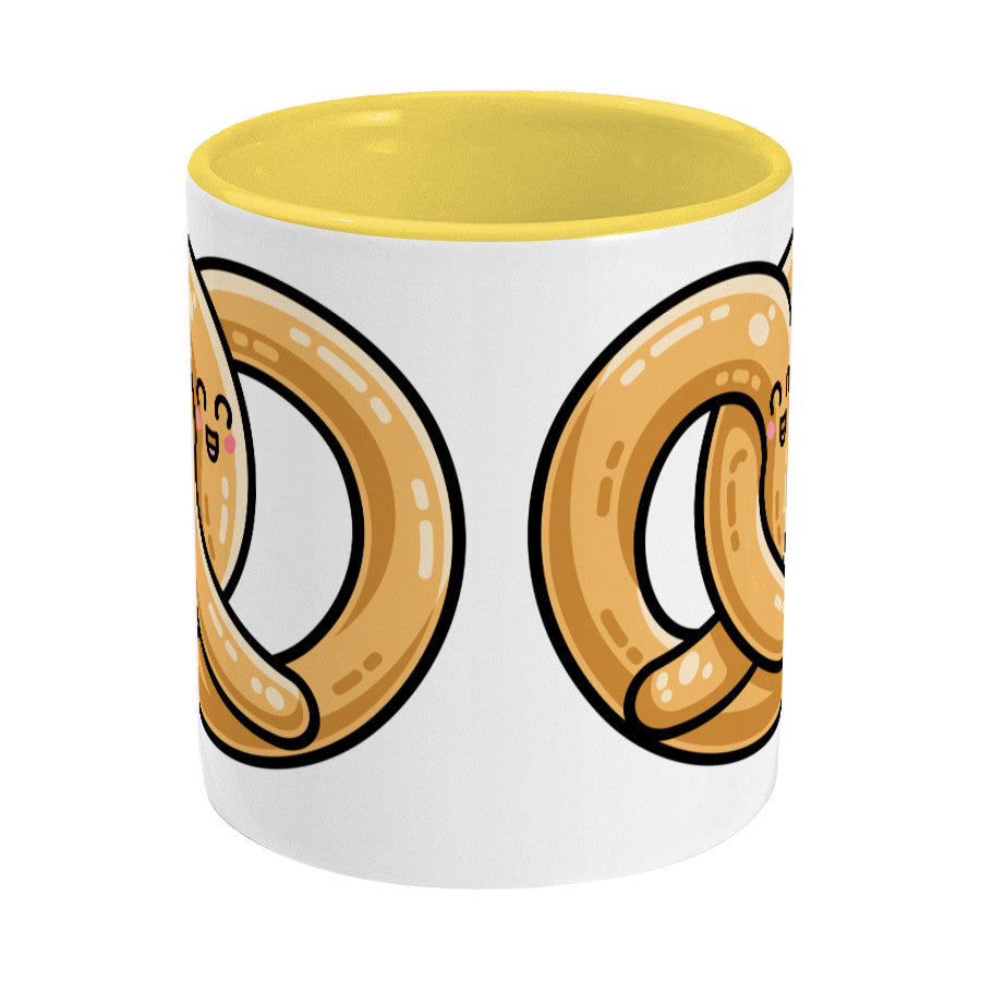 Kawaii cute pretzel design on a two toned yellow and white ceramic mug, side view