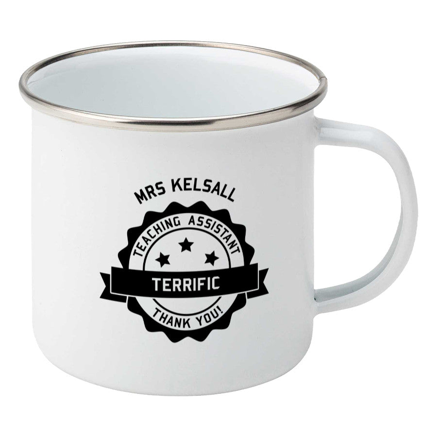 Personalised black circular banner design with the words 'terrific teaching assistant' on a silver rimmed white enamel mug, showing RHS