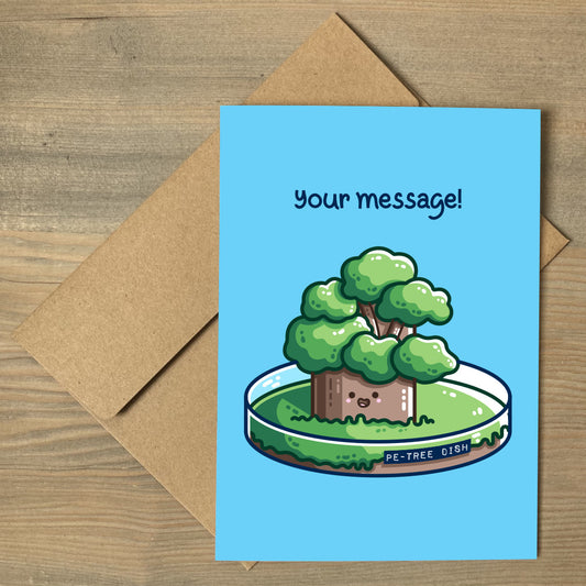 A blue greeting card lying flat on a brown envelope, with a design of a kawaii cute tree growing in a petri dish and the words above saying 'your message!'