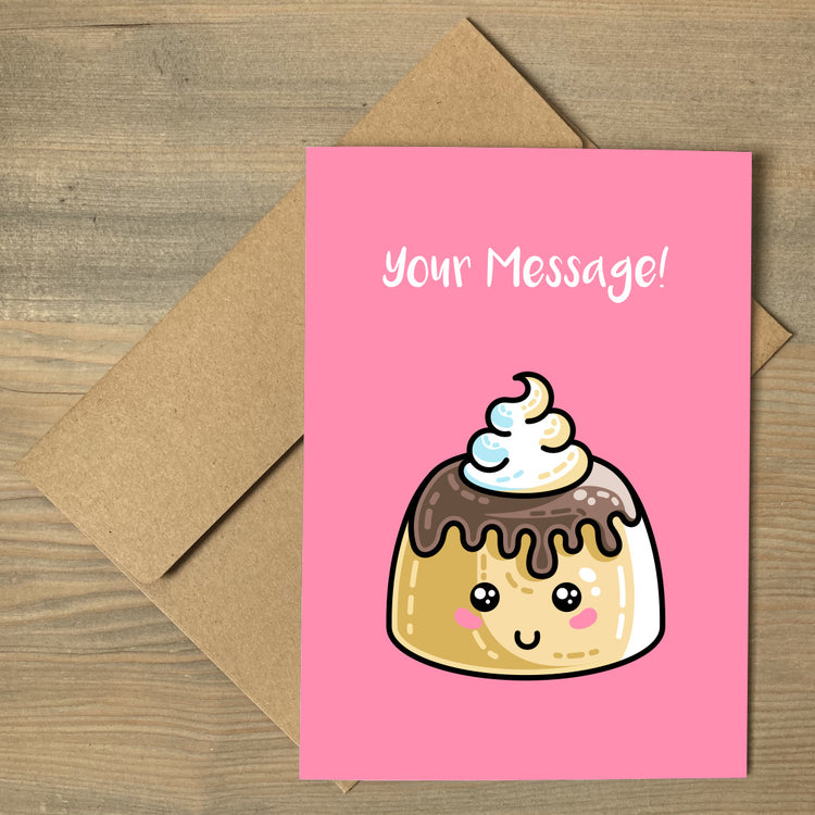 A pink greeting card lying flat on a brown envelope, with a design of a kawaii cute sponge pudding with cream and chocolate sauce on top and a personalised message above