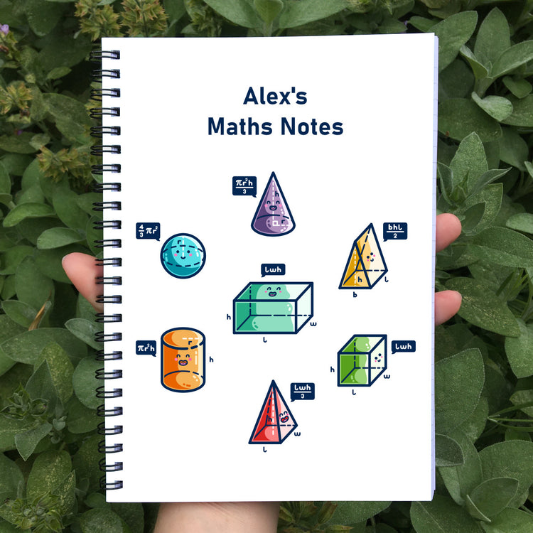 White spiral bound notebook held in a hand. The center of the front cover shows a honeycomb arrangement of 7 colourful 3D shapes, one of them in the middle, with happy faces and dark blue speech bubbles stating the maths to work out the volume of the shape. Centered above the shapes is the text Alex's Maths Notes.