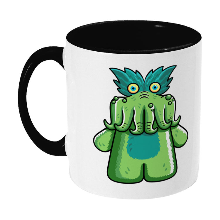 Green tickle-me-wiggly plush toy design on a two toned black and white ceramic mug, showing LHS