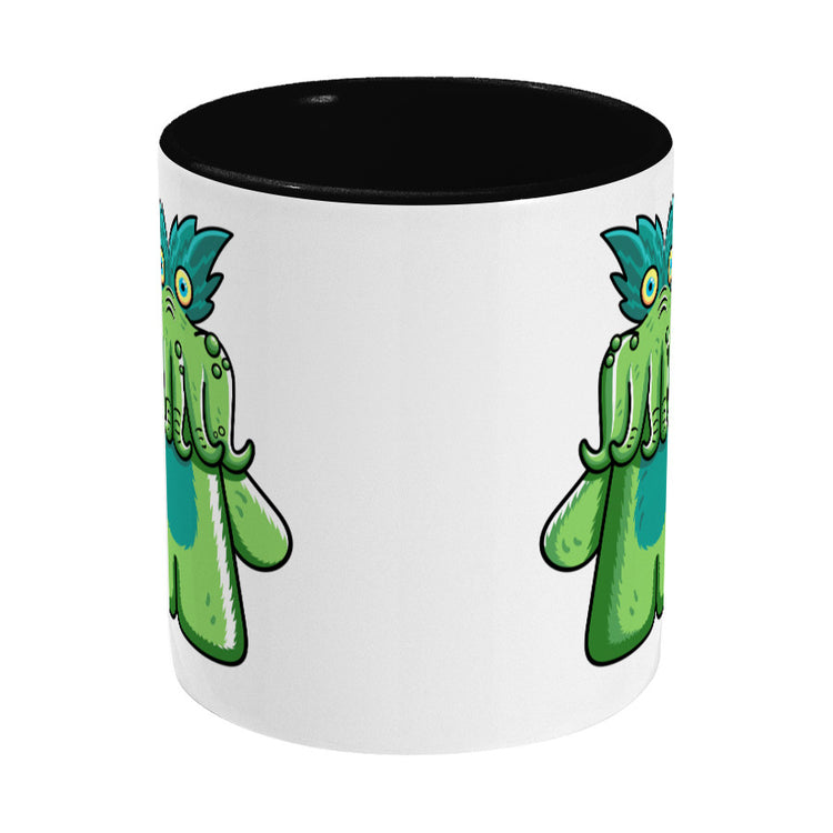 Green tickle-me-wiggly plush toy design on a two toned black and white ceramic mug, side view