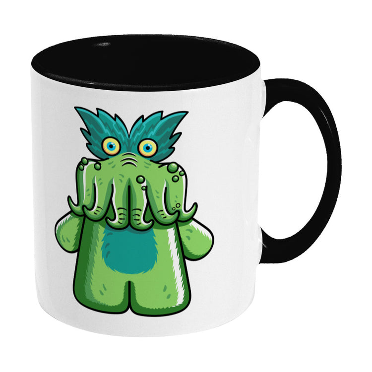 Green tickle-me-wiggly plush toy design on a two toned black and white ceramic mug, showing RHS